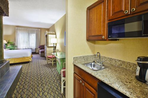 a hotel room with a kitchen and a bedroom at Holiday Inn Express Hotel & Suites - Belleville Area by IHG in Belleville