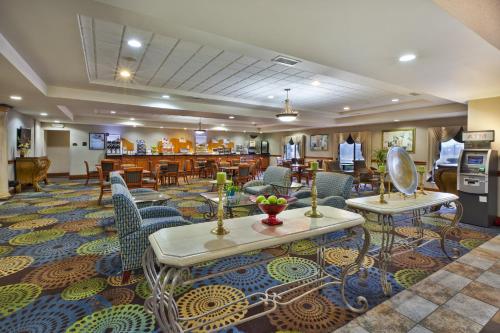 a hotel lobby with tables and chairs and a restaurant at Holiday Inn Express Hotel & Suites - Belleville Area by IHG in Belleville