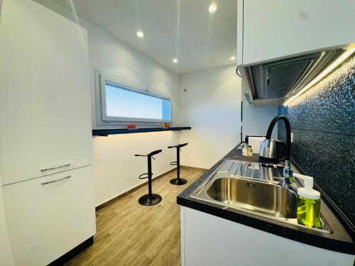 a small kitchen with a sink and a window at Al Grande Pino - Private pool, Jacuzzi and amazing Sunset in Campofelice di Roccella