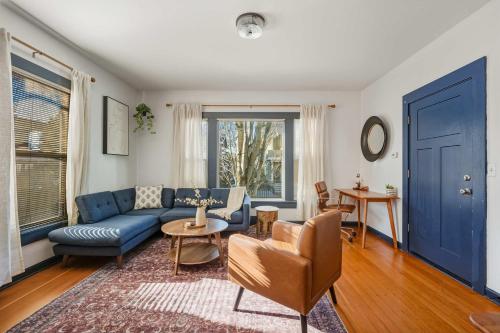 a living room with a blue couch and a table at Stay Portland - Perfectly Restored Craftsman - Eateries & Coffee in Portland