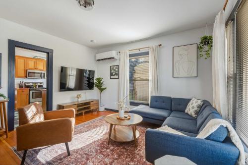 a living room with a blue couch and a table at Stay Portland - Perfectly Restored Craftsman - Eateries & Coffee in Portland