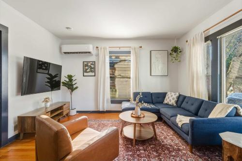 a living room with a blue couch and a tv at Stay Portland - Perfectly Restored Craftsman - Eateries & Coffee in Portland