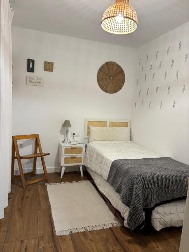 a bedroom with a bed and a table and a lamp at Valdefornos in Pontevedra