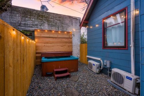 a hot tub sitting next to a blue house at Stay Portland - Cute & Charming Portland Home 91 WalkScore in Portland