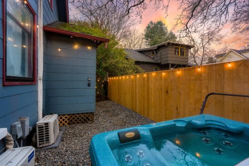 a hot tub in a yard next to a fence at Stay Portland - Cute & Charming Portland Home 91 WalkScore in Portland