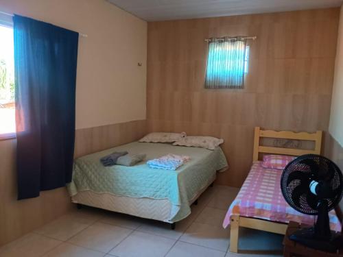 a small bedroom with a bed and a fan at AP Morro Branco in Beberibe