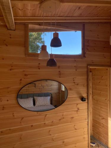 a circular mirror in a wooden room with a bed at Villa Haris in Sarti