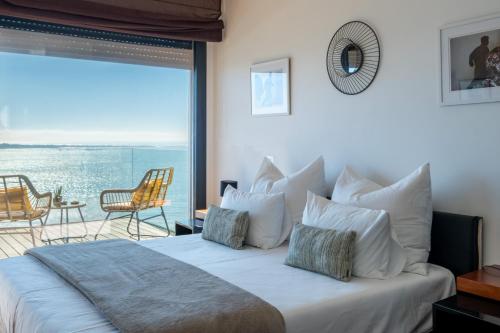 a bedroom with a bed with a view of the ocean at Modern Villa with Sea & River View Pool and Gym. in Lisbon