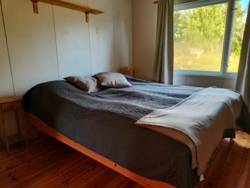 a bed with two pillows on it in a room with a window at Northern Cabin in Havukkavaara