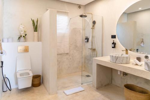 a bathroom with a shower and a toilet and a sink at Le Saint Tropez in Kidoti