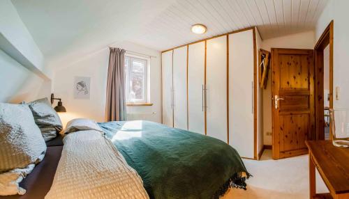a bedroom with a bed and a wooden cabinet at Ferienwohnung Ausblick in Süderbrarup