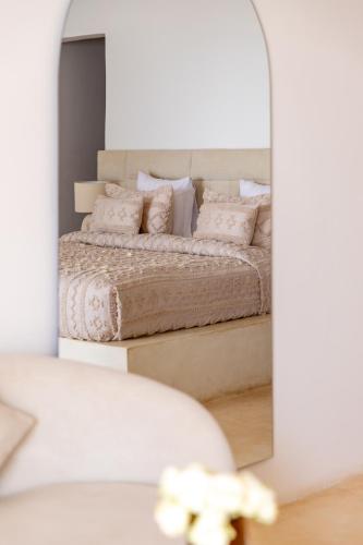 a bedroom with a bed in front of a mirror at Le Saint Tropez in Kidoti