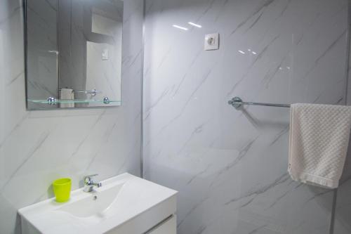 a white bathroom with a sink and a mirror at Apartment II Estrela da Calheta in Calheta