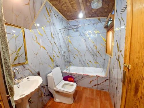 a bathroom with a toilet and a sink and a tub at Cheetah Palace in Srinagar
