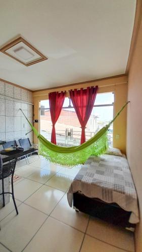 a bedroom with a hammock in the middle of a room at Flat Terra do Sol - Jijoca in Jijoca de Jericoacoara