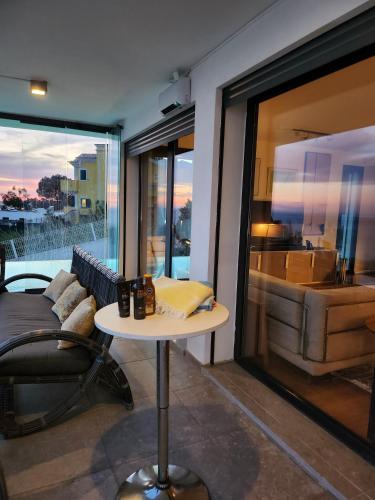 a room with a table and a couch and a window at Modern Villa with Sea & River View Pool and Gym. in Lisbon