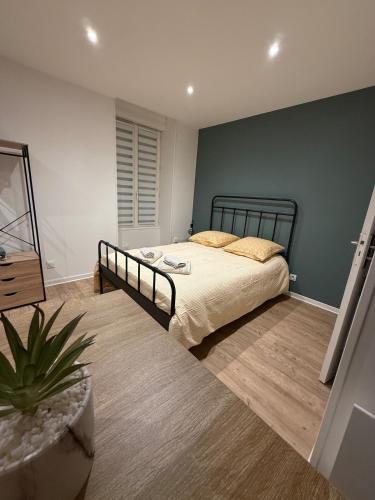 a bedroom with a bed and a green wall at Studio moderne tout confort in Vierzon