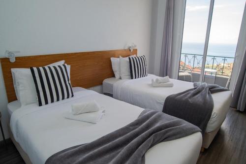 zwei Betten in einem Hotelzimmer mit Meerblick in der Unterkunft Sunset Star with Sea View in Calheta