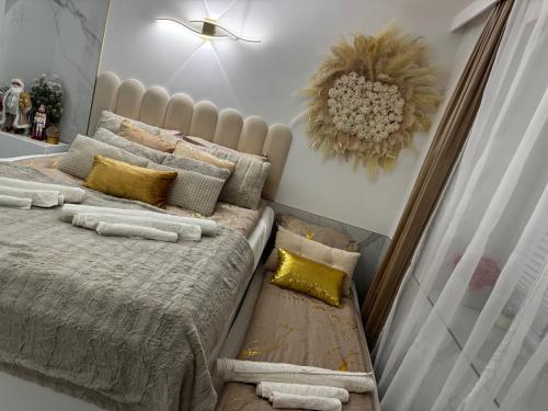 a bedroom with a large bed with gold pillows at Gold in Święta Katarzyna