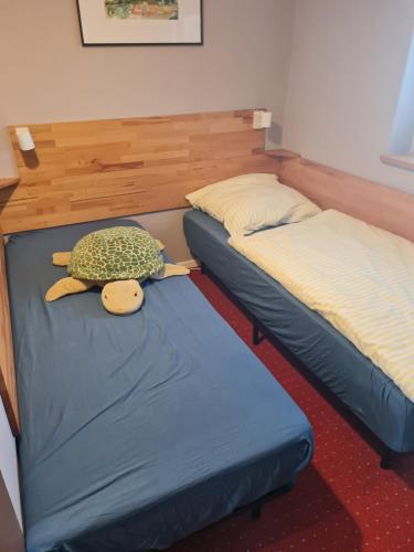 a bedroom with two beds with a stuffed turtle on the bed at Die große Wohnung in Droyßig
