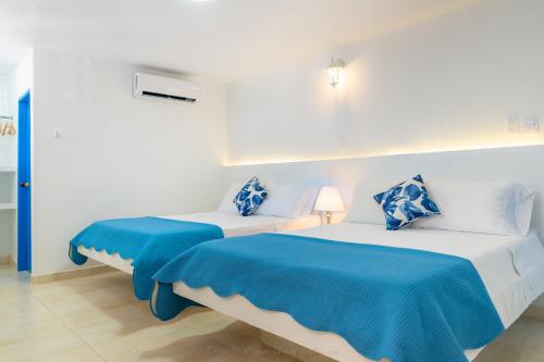 two beds in a room with blue and white at Casa Caribe Colonial in Barranquilla