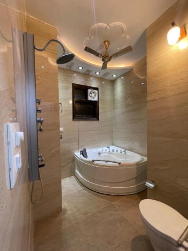 a bathroom with a tub and a toilet and a sink at Pacific Grand in Amritsar