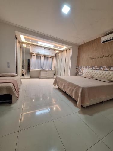 a large bedroom with two beds and a large tile floor at Casa com Piscina px Av Holandeses a 2km da Praia Araçagy in São Luís