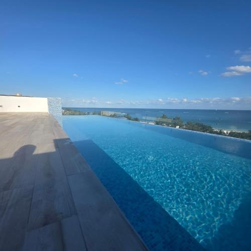 a swimming pool with a view of the ocean at MIRAMARE Ocean View in Puerto Morelos
