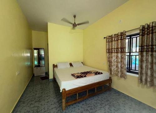 a bedroom with a bed and a window at Kudle Heaven in Gokarna