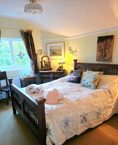 a bedroom with a large bed with stuffed animals on it at The Annexe Lurley Manor in Tiverton
