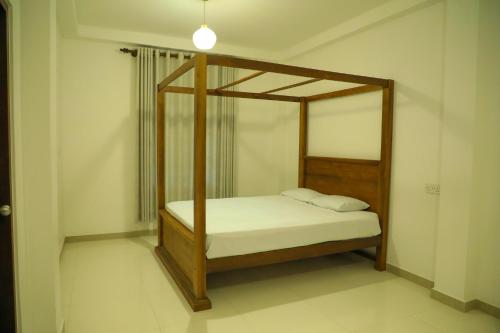 a bedroom with a canopy bed with white sheets at Cinnamon River Retreat in Magammana