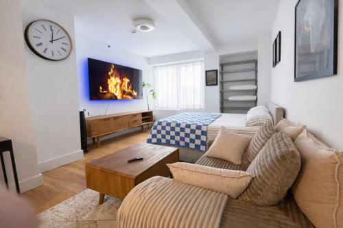 a living room with a couch and a bed and a clock at Modern Studio with Private Bathroom and Kitchen in New York