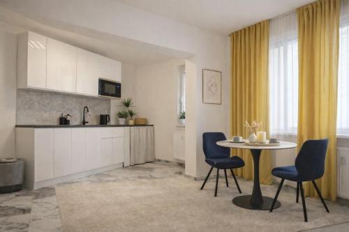 a kitchen and dining room with a table and chairs at Apartman VEMY in Trnava