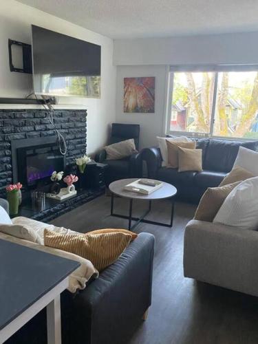 a living room with a couch and a fireplace at Quiet-comfy 3 bedroom house on a tree lined street in Kitsilano in Vancouver