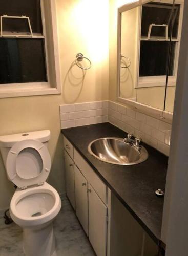 a bathroom with a toilet and a sink at Quiet-comfy 3 bedroom house on a tree lined street in Kitsilano in Vancouver