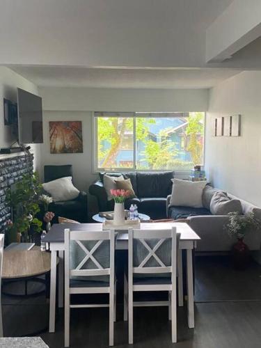 a living room with a couch and a table and chairs at Quiet-comfy 3 bedroom house on a tree lined street in Kitsilano in Vancouver