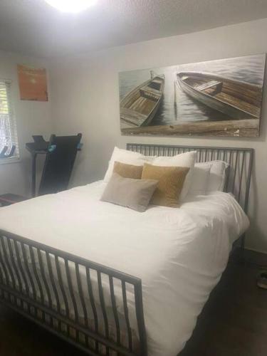 a bed with white sheets and pillows in a bedroom at Quiet-comfy 3 bedroom house on a tree lined street in Kitsilano in Vancouver