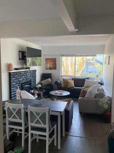 a living room with a couch and a table and chairs at Quiet-comfy 3 bedroom house on a tree lined street in Kitsilano in Vancouver