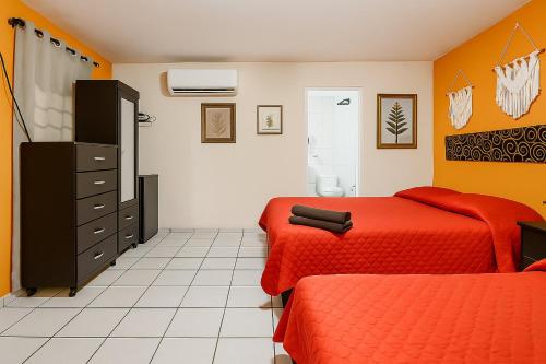 a bedroom with two beds and a dresser at Hotel Fundidora - Regiotitlan in Monterrey