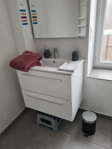a bathroom with a white sink with a red towel at L'Adeline Escapade de Charme et Calme proche Guédelon in Bléneau
