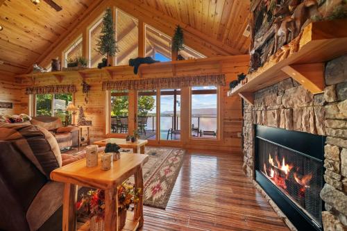 a living room with a fireplace in a log cabin at Cozy Cabin Style Lake House w Theatre Room & Dock in Sevierville