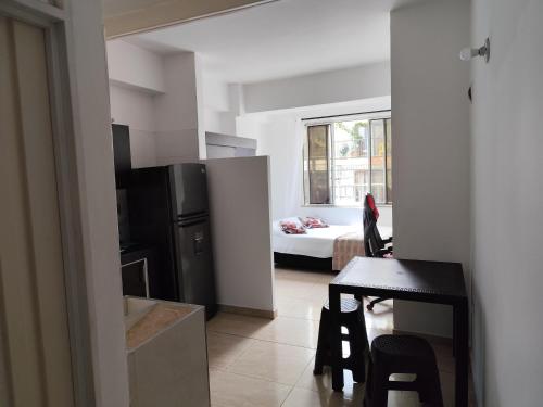 a room with a kitchen and a dining room with a table at Edificio Wil Hostal Apt 201 in Cali
