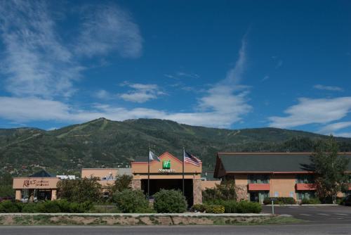 a building with a flag in front of a mountain at Holiday Inn Steamboat Springs by IHG in Steamboat Springs