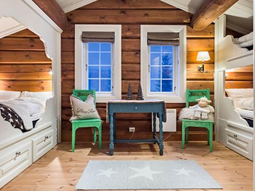 a bedroom with a blue desk and two green chairs at Mountain Lodge with Jacuzzi & Views in Aurdal