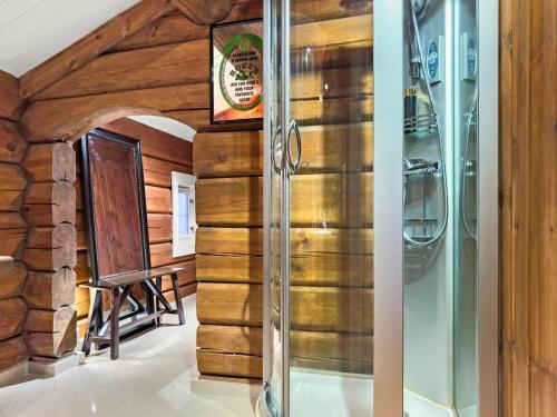 a bathroom with wooden walls and a glass shower stall at Mountain Lodge with Jacuzzi & Views in Aurdal