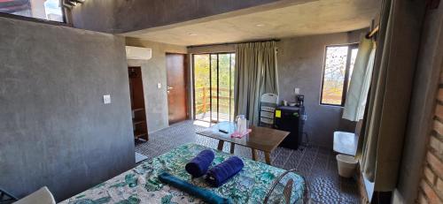 ein Zimmer mit einem Bett, einem Tisch und einem Fenster in der Unterkunft Parcela in Mazunte