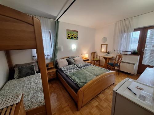 ein Schlafzimmer mit einem Bett, einem Schreibtisch und einem Tisch in der Unterkunft Mia apartment in Zreče