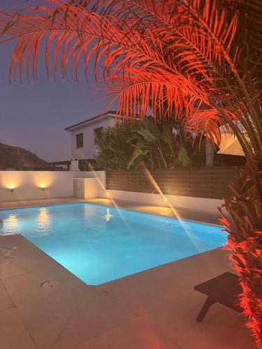a large blue swimming pool in a backyard at night at Katikies Grand - Superior Villa Adults Only in Pissouri