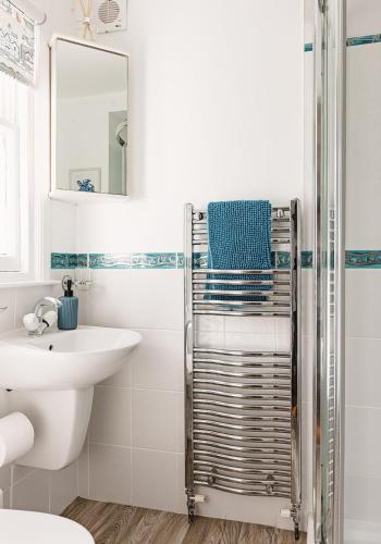 a white bathroom with a sink and a shower at Doug's Cottage in Elie