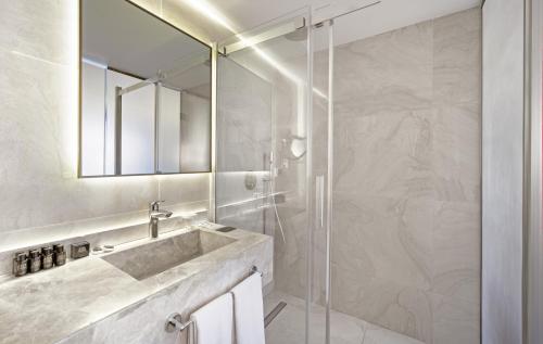 a bathroom with a sink and a shower with a mirror at Great Fortune Concept Hotel in Istanbul